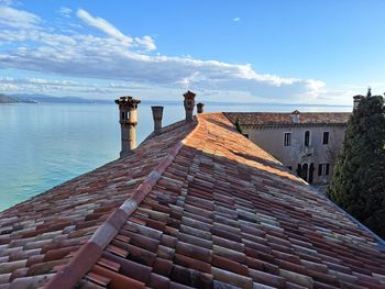 Roof of building by sea against sky