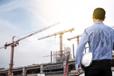 Rear view of architect standing against incomplete building