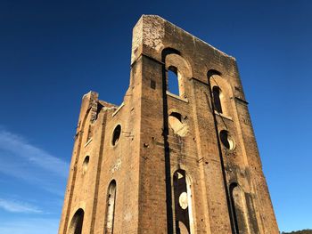 Low angle view of old building against blue sky