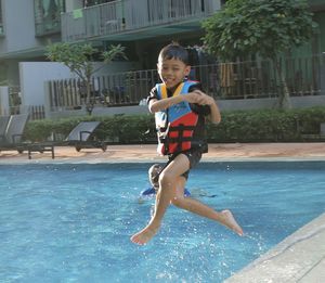 Portrait of young woman jumping in water