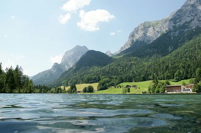 Scenic view of lake by mountains against sky