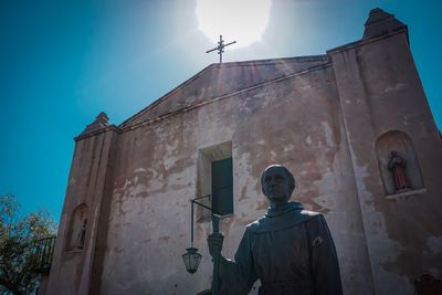 Low angle view of man on building against sky