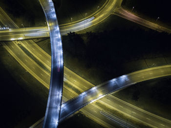 Light trails on road against sky at night