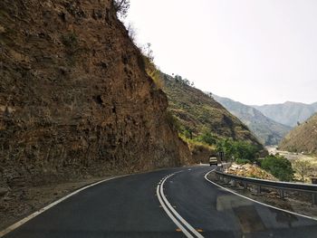 Road by mountain against sky