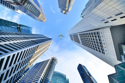 Directly below view of airplane flying over skyscrapers