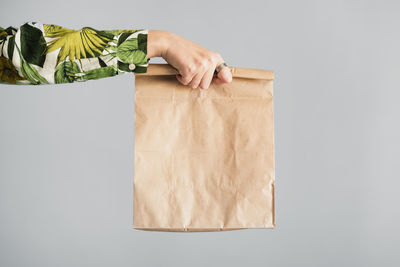 Midsection of man holding paper against white background