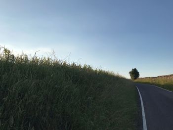 Road amidst field against sky