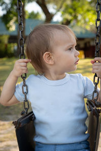 Cute girl holding swing in playground