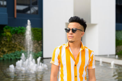 Portrait of young man wearing sunglasses standing outdoors