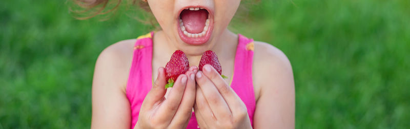 Midsection of girl eating strawberry