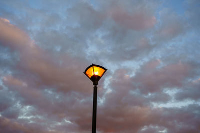 Low angle view of street light against cloudy sky