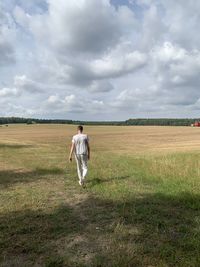 Full length of man standing on field against sky