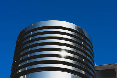 Low angle view of modern building against blue sky