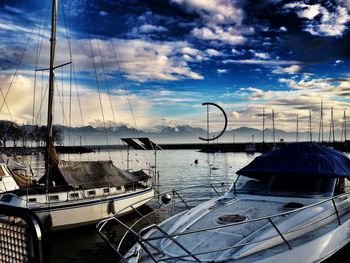 Boats in sea against cloudy sky