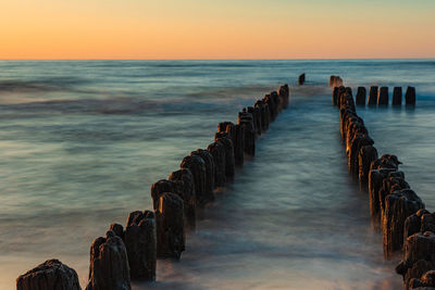 Pier over sea against sky during sunset