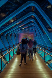 Rear view of people walking on footbridge