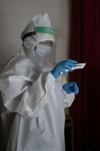 Woman wearing protective suit standing indoors