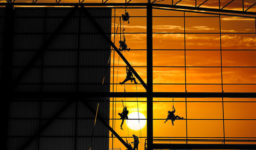 Silhouette of structure for steel wall frame installation by worker team