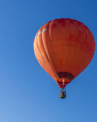 Low angle view of hot air balloon against clear blue sky