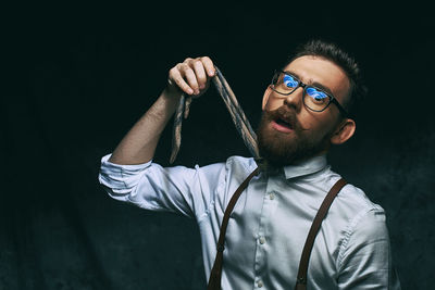 Portrait of young man against black background