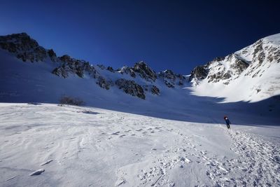 People skiing on snowcapped mountain against sky