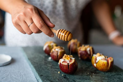 Close-up of person holding fruits on table