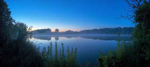 Scenic view of lake against clear blue sky