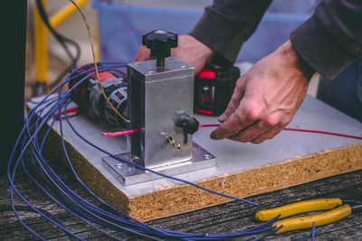 Midsection of man with machinery working in factory