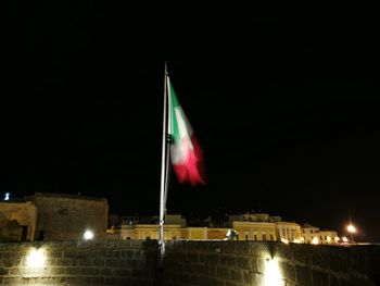 Low angle view of illuminated flag against clear sky at night