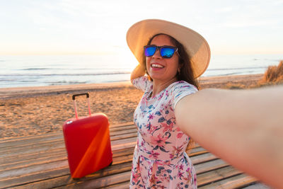 Smiling woman doing selfie at beach