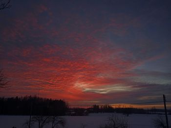 Scenic view of snow covered landscape against sky during sunset