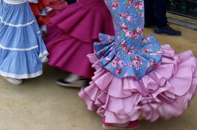 Low section of woman standing on pink umbrella