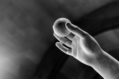 Cropped image of human statue against ceiling