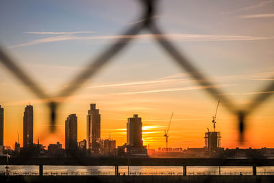 Silhouette buildings against sky during sunset