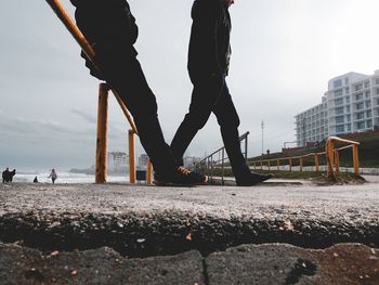 Low section of people walking on road in city