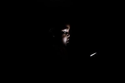 Portrait of young man against black background