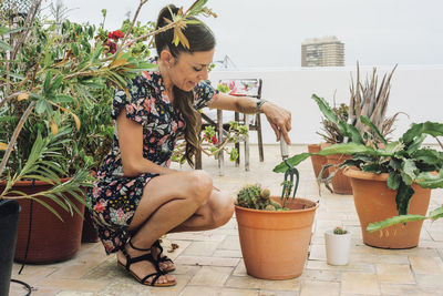 Woman sitting on potted plant