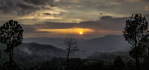 Scenic view of silhouette mountains against sky at sunset