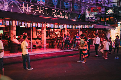 Group of people against illuminated building at night