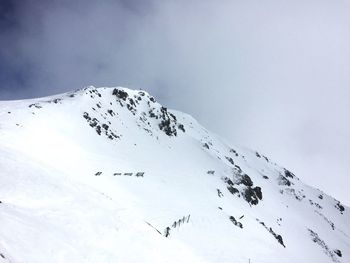 Scenic view of snowcapped mountains against cloudy sky