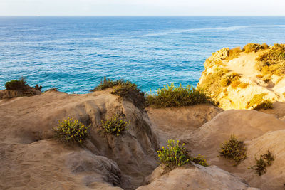 Scenic view of rocks on beach against sky