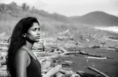 Side view of beautiful young woman at beach