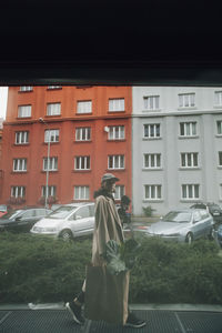 Rear view of woman on car against city