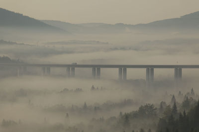 Scenic view of bridge over mountains against sky