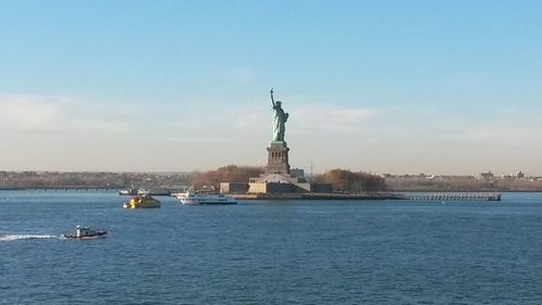 Statue in sea against sky