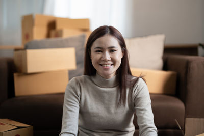 Portrait of young woman sitting on sofa at home