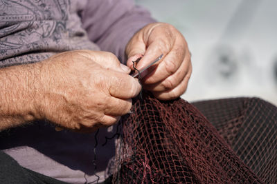 Midsection of man holding fishing net