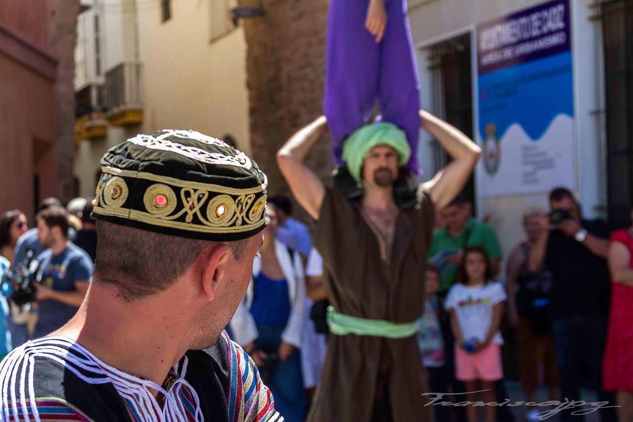 focus on foreground, lifestyles, leisure activity, person, celebration, casual clothing, holding, men, standing, large group of people, cultures, front view, day, traditional clothing, close-up, incidental people, young adult, outdoors