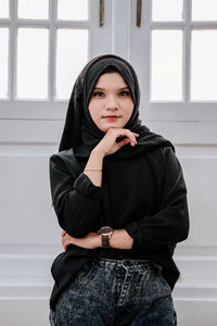 Beautiful woman wearing hijab is posing in a cafe