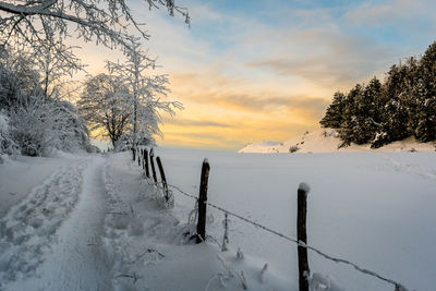 Scenic view of snow covered field against sky during winter